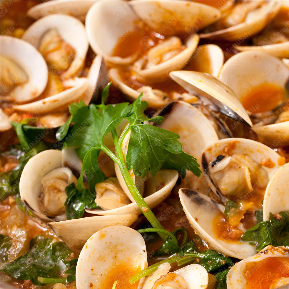 Spicy clams in red sauce with greens at Ocean Crab Marysville, a Seafood Restaurant in Marysville
